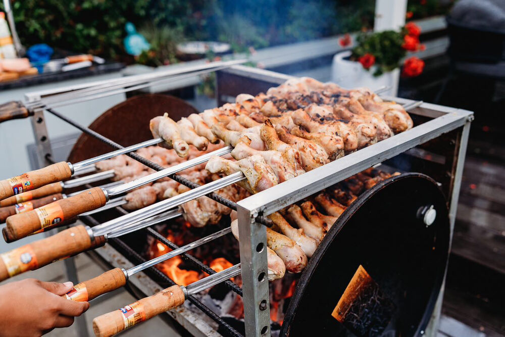 Chicken drumsticks grilling on skewers